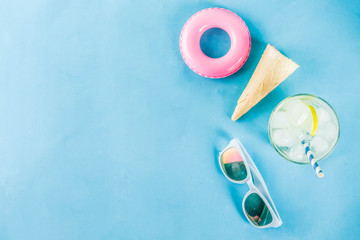 Summer holidays vacation concept background, hat, sunglasses, cooling drink (lemonade, mojito) with ice, ice cream cones, Lifebuoy blue background copy space flatlay above