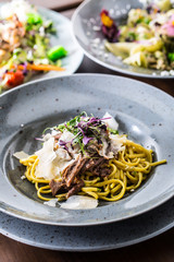 Pasta linguine with confit duck breast parmesan cheese and herb decoration