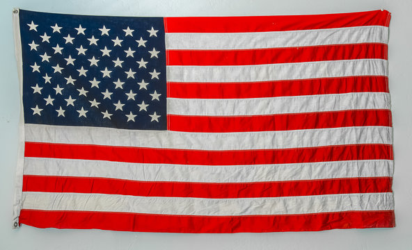 Worn american flag hanging from wall