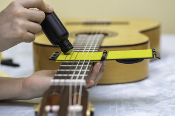 Fototapeta premium Pielęgnacja i konserwacja strun gitary.
