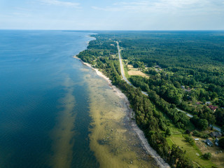 Fototapeta na wymiar drone image. aerial view of Baltic sea shore with rocks and forest on land and highway near water