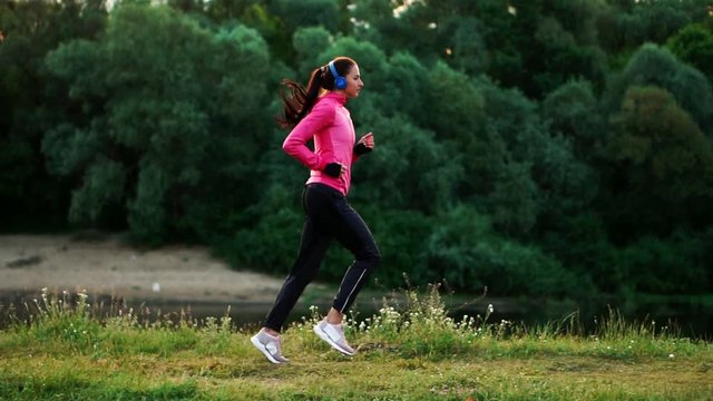 A morning jog in the Park near the pond in the Sunny rays of dawn, the girl is preparing to Mariano and lead a healthy lifestyle