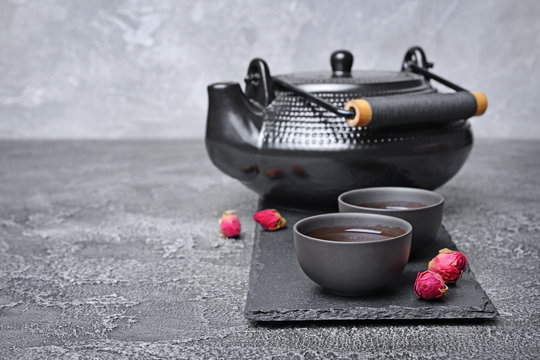 Asian black traditional teapot and teacups with healthy herbal rose tea