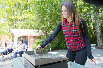 Woman cooking pancakes for breakfast at camp