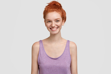 Obraz premium Touched happy freckled female with ginger hair, happy to recieve confession in love, smiles positively, dressed in casual t shirt, isolated over white background. People, beauty, positive expressions