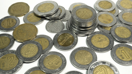 Mexican pesos, old and damaged Mexico coins on white background, editorial and illustrative image.