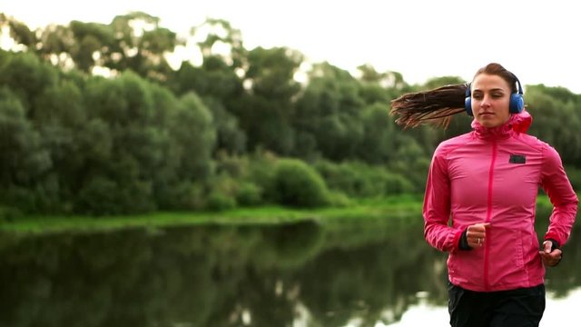A morning jog in the Park near the pond in the Sunny rays of dawn, the girl is preparing to Mariano and lead a healthy lifestyle