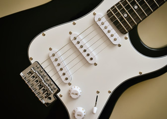 Parts of electric guitar body and neck on the wooden background. Close-up. 