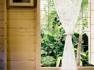 Vintage white curtains on soft light window.