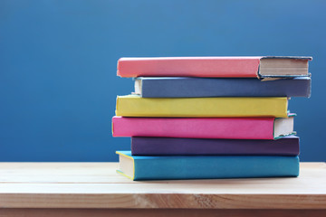 stack of books in the colored cover on the table. Reading, education, library.