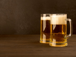 Two glasses of lager served on old wooden planks, copyspace for text