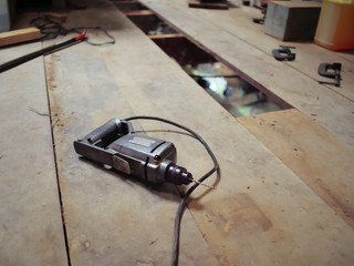 Electric drill on the wooden floor