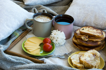 Delicious breakfast in bed with toast and a big cup of coffee