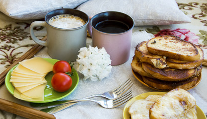 Delicious breakfast in bed with toast and a big cup of coffee