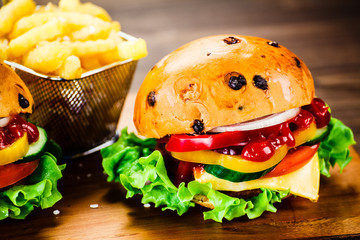 Tasty burgers with chips served on cutting board