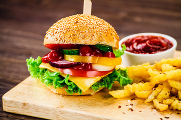 Tasty burger with chips served on cutting board