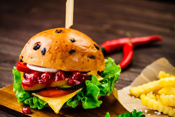 Tasty burger with chips served on cutting board