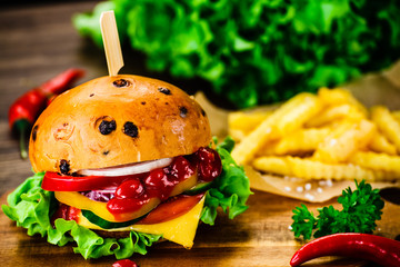 Tasty burger with chips served on cutting board