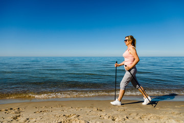Nordic walking - woman training on beach