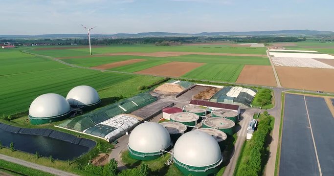 Wind turbine and biogas plant in green field, alternative energy sources, renewable energy