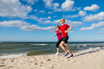 Woman and man running on beach