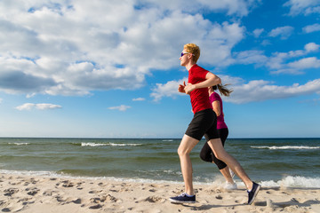 Woman and man running on beach