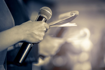 Master of ceremonies with microphone on stage - obrazy, fototapety, plakaty