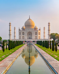 Taj Mahal front view reflected on the reflection pool, an ivory-white marble mausoleum on the south...