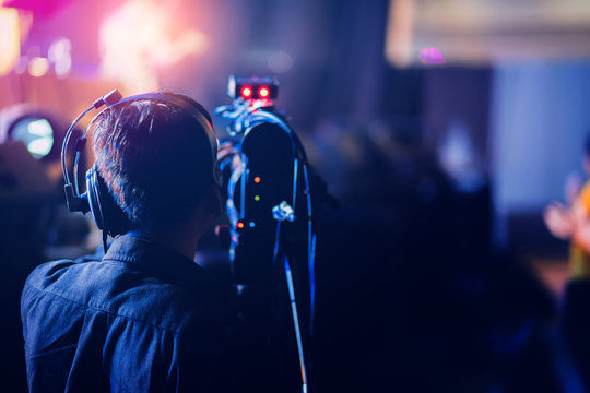 professional cameraman record live concert with beam spot and light performance