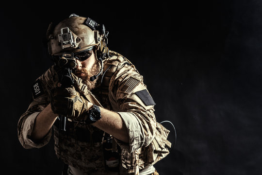 Special forces soldier with rifle on dark background