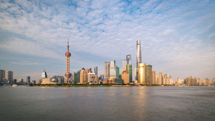 Obraz premium Shanghai city skyline Pudong side looking through Huangpu river on a sunny day. Shanghai, Chima. Beutiful vibrant panoramic image.
