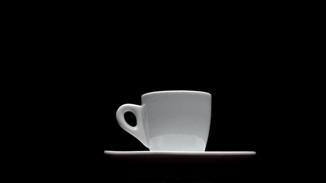 A cup of hot coffee on a black background