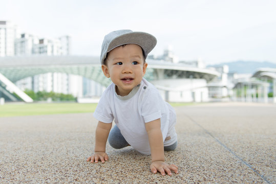 Beautiful baby boy crawling outdoor in park, learn to walk