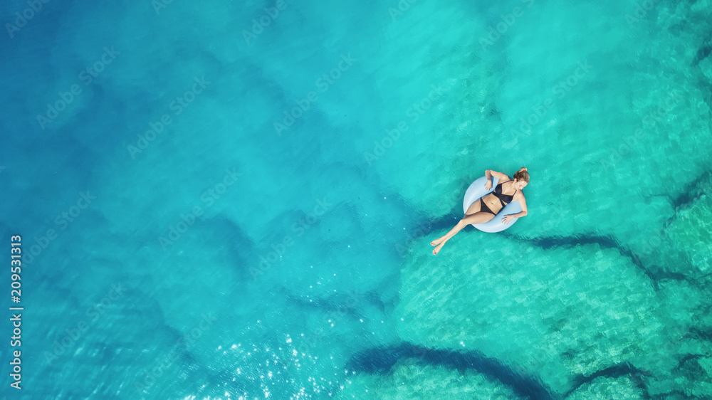 Wall mural aerial view at the girl on sea surface. beautiful composition at the summer time