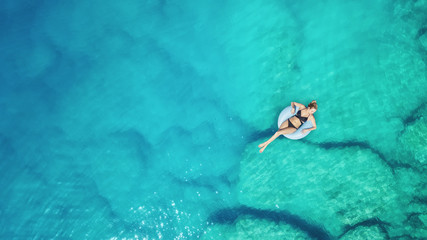 Aerial view at the girl on sea surface. Beautiful composition at the summer time
