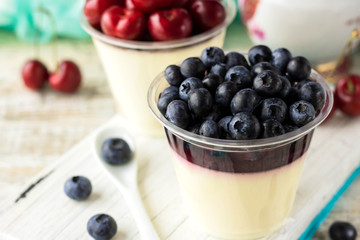 Italian dessert pana cota with berry jam and fresh blueberries
