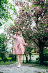 Young Woman in Red Striped Dress Walking in Garden