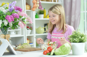 Obraz na płótnie Canvas Cute little girl preparing fresh salad