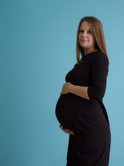 Portrait of pregnant woman over blue background