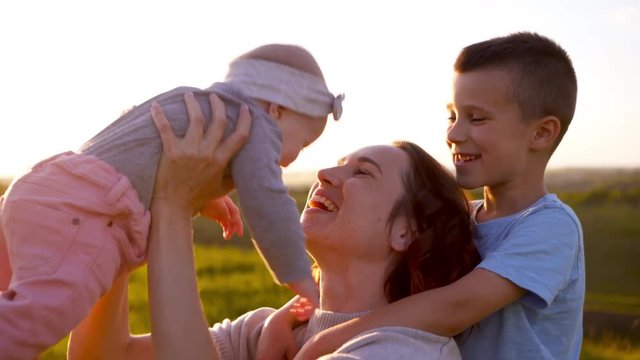 Loving mother having fun with kids in field