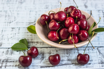 Fresh cherry on plate on wooden blue background. fresh ripe cherries. sweet cherries.