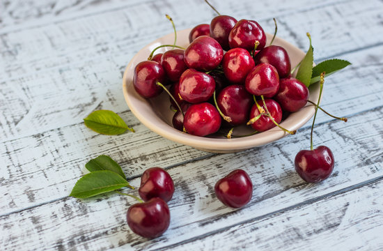 Fresh cherry on plate on wooden blue background. fresh ripe cherries. sweet cherries.