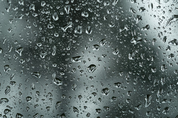 raindrops on a glass window of a car in forest