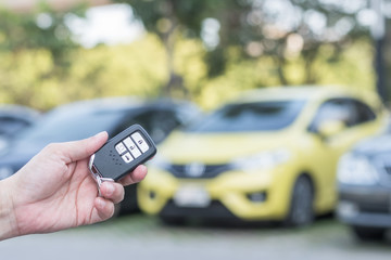 Car valet parking service business concept with people handling car key on blur parking lot background