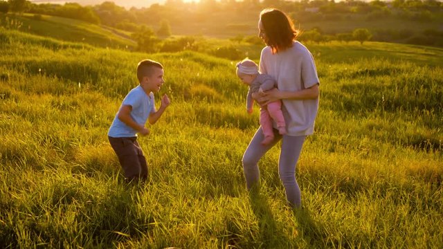 Adorable family having fun outdoors while dancing in field