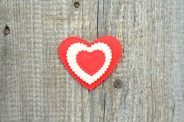 A beautiful soft heart made of cloth on an old board. Close-up. Background. Texture.