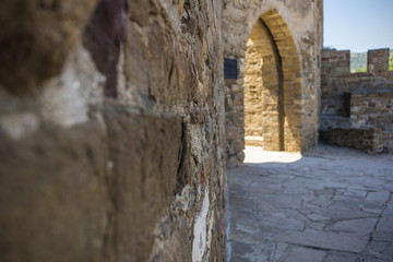 Courtyard of an ancient castle with an arch, view from the wall close-up, selective focus, background