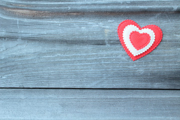 A beautiful heart made of cloth on an old board. Close-up. Background. Texture. Valentine's Day.