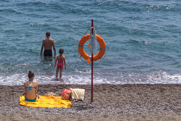 Happy family is resting on the beach by the sea. The concept of summer holidays