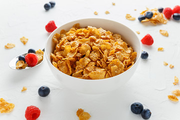 Morning healthy Breakfast honey Cornflakes with fresh fruits of Raspberry, blueberries